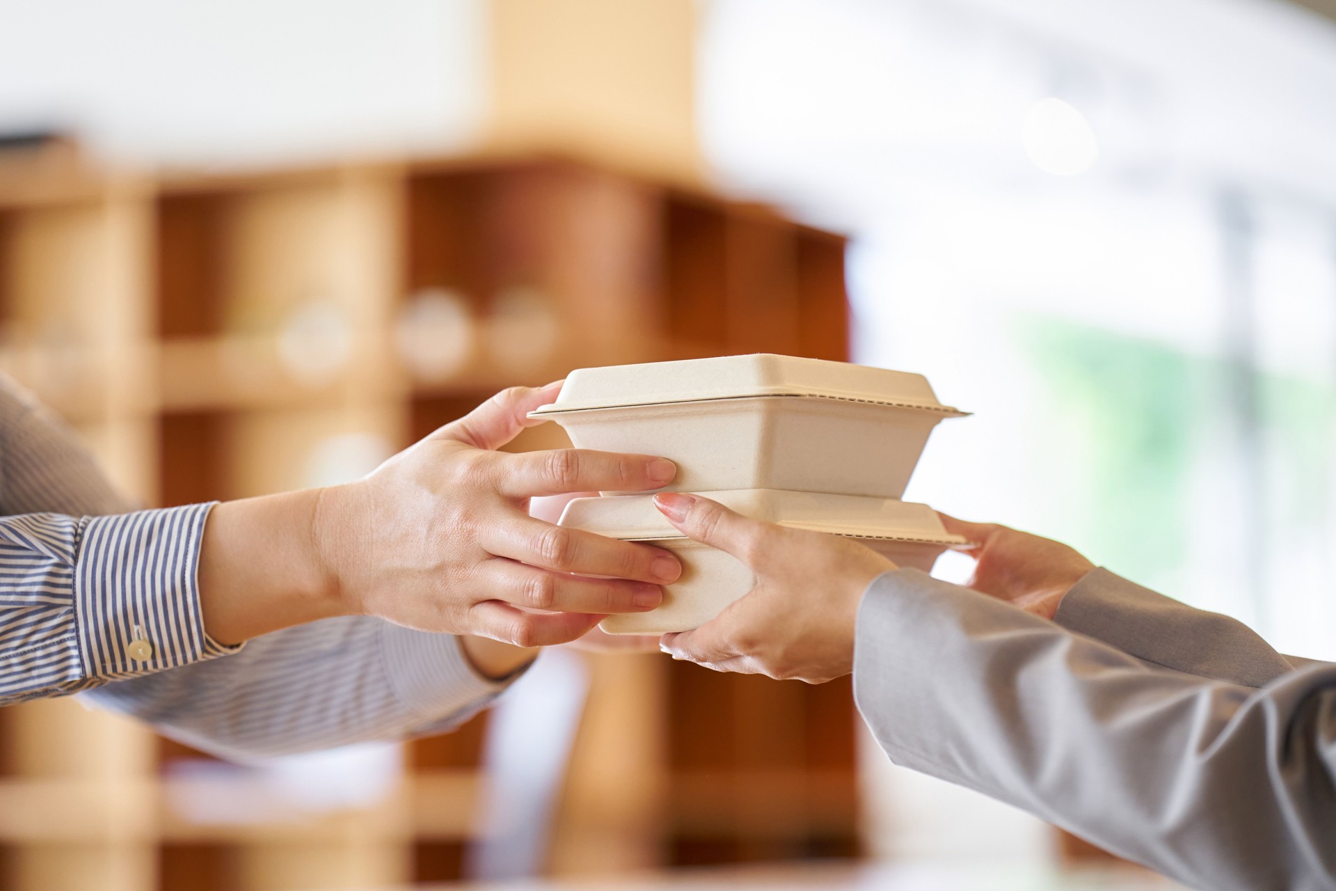 Restaurant employee handing out take-out lunch